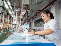 A worker is working on a production line at a workshop of a textile company in Nantong, China, on August 15, 2024. (