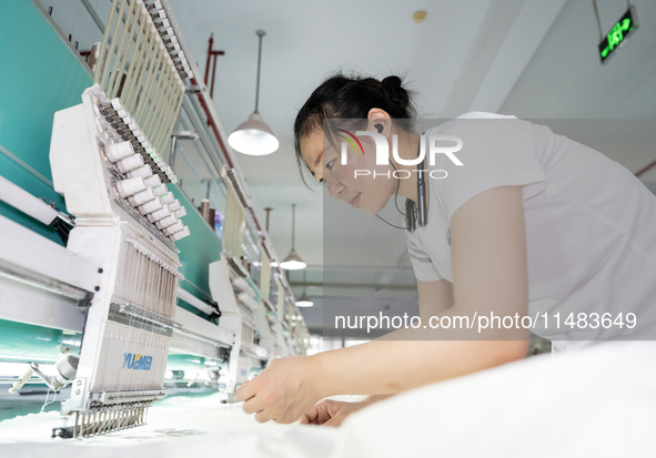 A worker is working on a production line at a workshop of a textile company in Nantong, China, on August 15, 2024. 