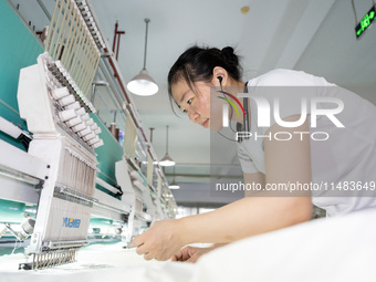 A worker is working on a production line at a workshop of a textile company in Nantong, China, on August 15, 2024. (