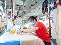 A worker is working on a production line at a workshop of a textile company in Nantong, China, on August 15, 2024. (