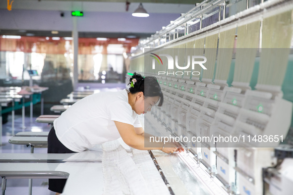 A worker is working on a production line at a workshop of a textile company in Nantong, China, on August 15, 2024. 