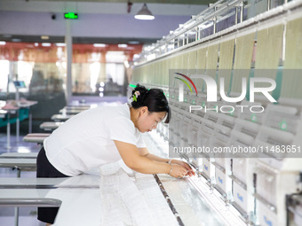 A worker is working on a production line at a workshop of a textile company in Nantong, China, on August 15, 2024. (