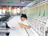 A worker is working on a production line at a workshop of a textile company in Nantong, China, on August 15, 2024. (