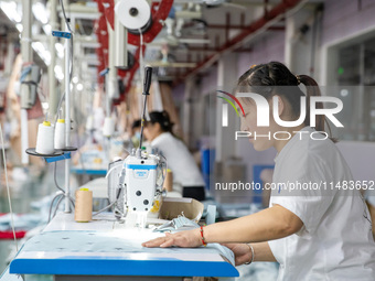 A worker is working on a production line at a workshop of a textile company in Nantong, China, on August 15, 2024. (