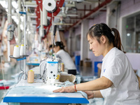 A worker is working on a production line at a workshop of a textile company in Nantong, China, on August 15, 2024. (