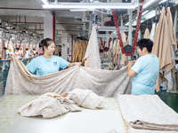 Workers are working on a production line at a workshop of a textile company in Nantong, Jiangsu province, China, on August 15, 2024. (