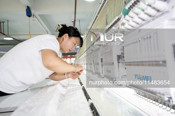 A worker is working on a production line at a workshop of a textile company in Nantong, China, on August 15, 2024. 