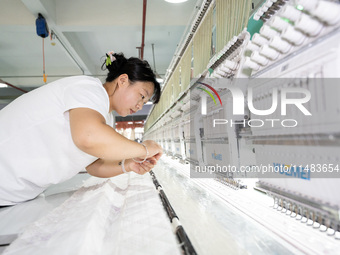 A worker is working on a production line at a workshop of a textile company in Nantong, China, on August 15, 2024. (