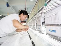 A worker is working on a production line at a workshop of a textile company in Nantong, China, on August 15, 2024. (