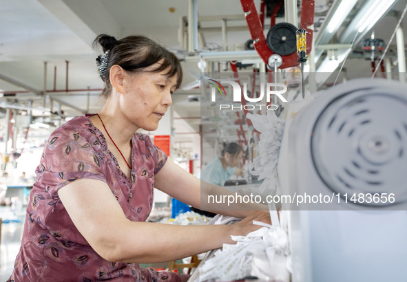 A worker is working on a production line at a workshop of a textile company in Nantong, China, on August 15, 2024. 