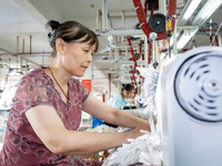 A worker is working on a production line at a workshop of a textile company in Nantong, China, on August 15, 2024. (