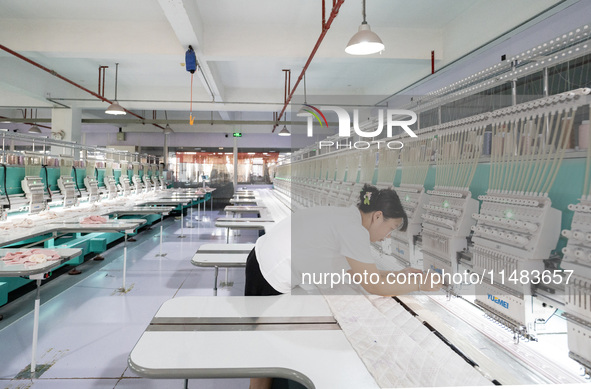 A worker is working on a production line at a workshop of a textile company in Nantong, China, on August 15, 2024. 