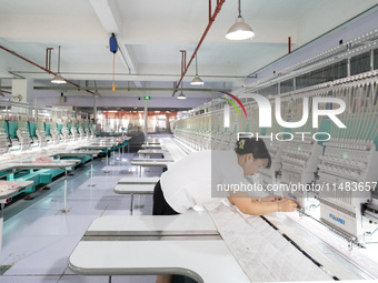 A worker is working on a production line at a workshop of a textile company in Nantong, China, on August 15, 2024. (