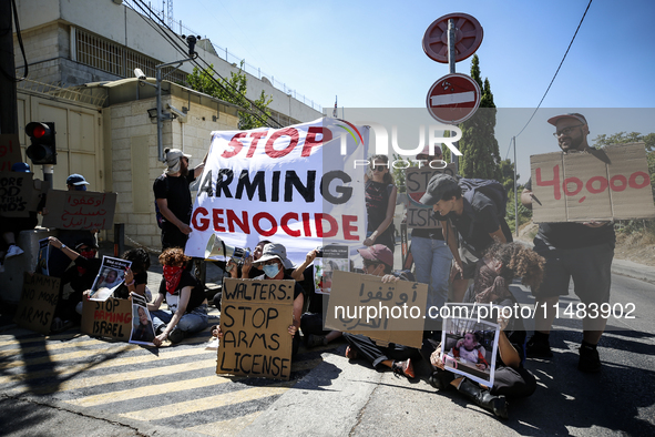 Chained Israeli protesters are holding placards in a protest to call for an end to the war in Gaza, during Britain's Foreign Secretary David...