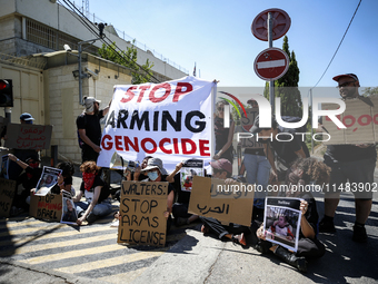 Chained Israeli protesters are holding placards in a protest to call for an end to the war in Gaza, during Britain's Foreign Secretary David...