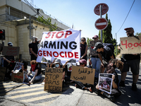 Chained Israeli protesters are holding placards in a protest to call for an end to the war in Gaza, during Britain's Foreign Secretary David...