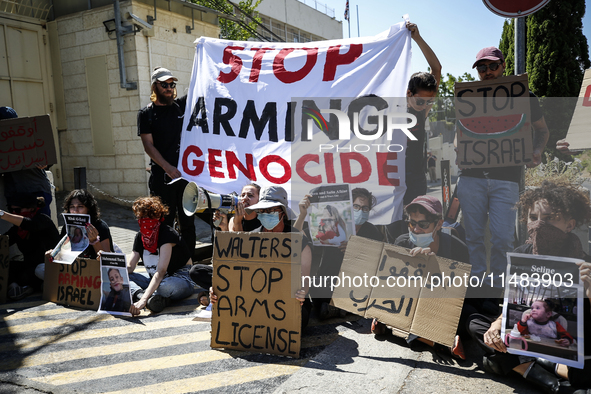 Chained Israeli protesters are holding placards in a protest to call for an end to the war in Gaza, during Britain's Foreign Secretary David...