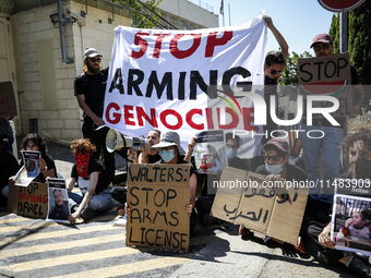 Chained Israeli protesters are holding placards in a protest to call for an end to the war in Gaza, during Britain's Foreign Secretary David...