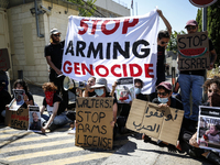 Chained Israeli protesters are holding placards in a protest to call for an end to the war in Gaza, during Britain's Foreign Secretary David...