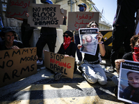 Chained Israeli protesters are holding placards in a protest to call for an end to the war in Gaza, during Britain's Foreign Secretary David...