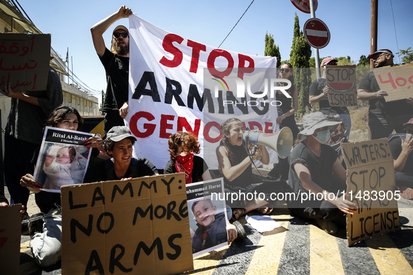 Chained Israeli protesters are holding placards in a protest to call for an end to the war in Gaza, during Britain's Foreign Secretary David...