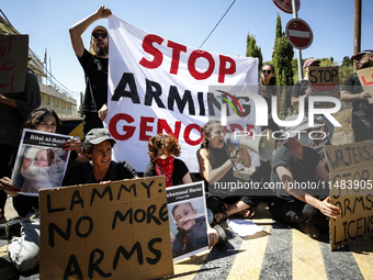 Chained Israeli protesters are holding placards in a protest to call for an end to the war in Gaza, during Britain's Foreign Secretary David...