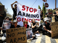 Chained Israeli protesters are holding placards in a protest to call for an end to the war in Gaza, during Britain's Foreign Secretary David...