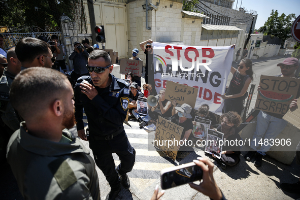 Chained Israeli protesters are holding placards in a protest to call for an end to the war in Gaza, during Britain's Foreign Secretary David...