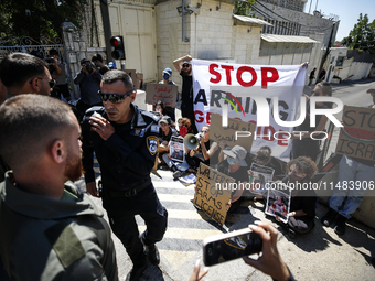 Chained Israeli protesters are holding placards in a protest to call for an end to the war in Gaza, during Britain's Foreign Secretary David...