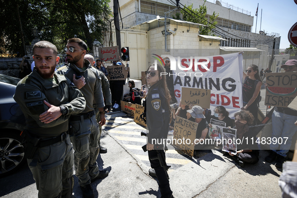 Chained Israeli protesters are holding placards in a protest to call for an end to the war in Gaza, during Britain's Foreign Secretary David...