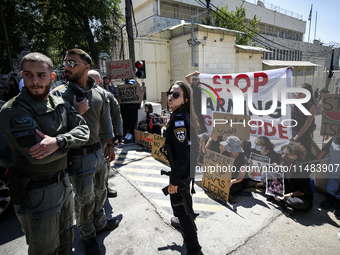 Chained Israeli protesters are holding placards in a protest to call for an end to the war in Gaza, during Britain's Foreign Secretary David...