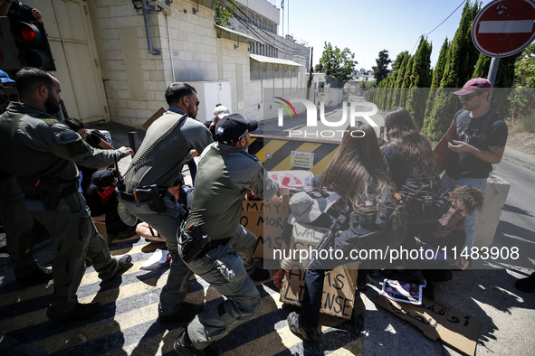 Chained Israeli protesters are arguing with police officers during a protest to call for an end to the war in Gaza, during Britain's Foreign...