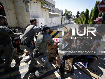 Chained Israeli protesters are arguing with police officers during a protest to call for an end to the war in Gaza, during Britain's Foreign...