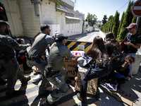 Chained Israeli protesters are arguing with police officers during a protest to call for an end to the war in Gaza, during Britain's Foreign...