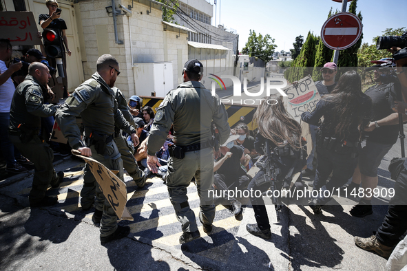 Chained Israeli protesters are arguing with police officers during a protest to call for an end to the war in Gaza, during Britain's Foreign...