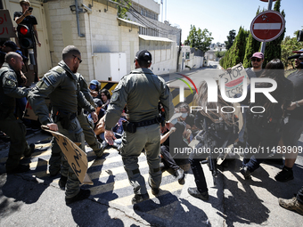 Chained Israeli protesters are arguing with police officers during a protest to call for an end to the war in Gaza, during Britain's Foreign...