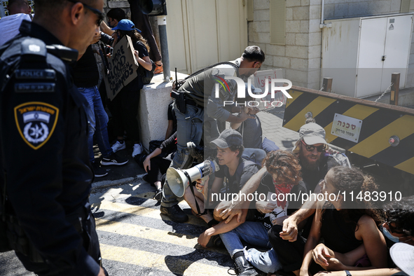 Chained Israeli protesters are arguing with police officers during a protest to call for an end to the war in Gaza, during Britain's Foreign...