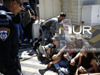 Chained Israeli protesters are arguing with police officers during a protest to call for an end to the war in Gaza, during Britain's Foreign...