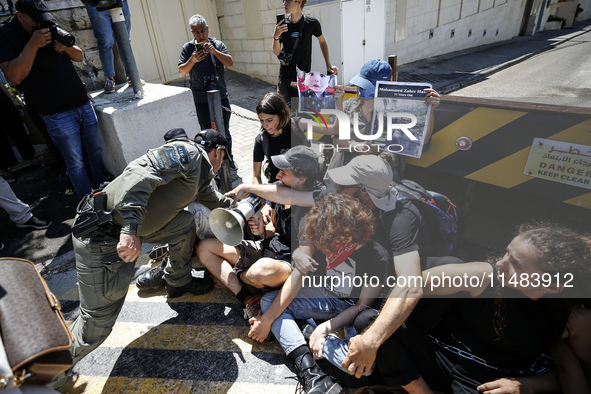 Chained Israeli protesters are arguing with police officers during a protest to call for an end to the war in Gaza, during Britain's Foreign...