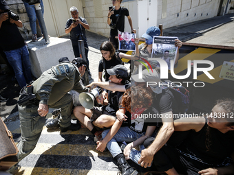 Chained Israeli protesters are arguing with police officers during a protest to call for an end to the war in Gaza, during Britain's Foreign...