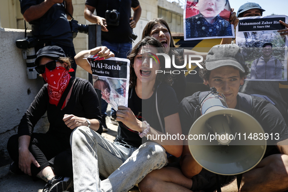 Chained Israeli protesters are holding placards in a protest to call for an end to the war in Gaza, during Britain's Foreign Secretary David...