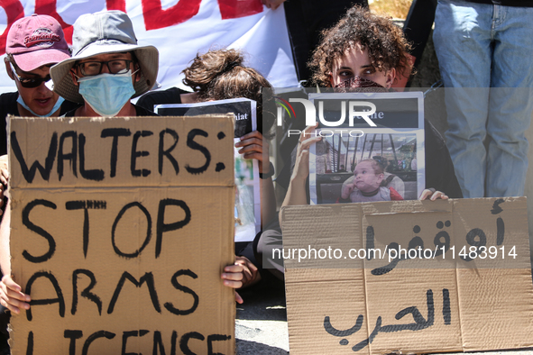 Israeli protesters are holding placards in a protest to call for an end to the war in Gaza, during Britain's Foreign Secretary David Lammy's...