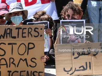 Israeli protesters are holding placards in a protest to call for an end to the war in Gaza, during Britain's Foreign Secretary David Lammy's...