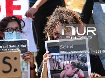 Chained Israeli protesters are holding placards in a protest to call for an end to the war in Gaza, during Britain's Foreign Secretary David...