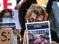 Chained Israeli protesters are holding placards in a protest to call for an end to the war in Gaza, during Britain's Foreign Secretary David...