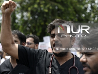 Medical professionals are shouting slogans and holding placards to protest against the rape and murder of a trainee medic at a government-ru...