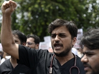 Medical professionals are shouting slogans and holding placards to protest against the rape and murder of a trainee medic at a government-ru...