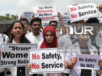 Medical professionals are shouting slogans and holding placards to protest against the rape and murder of a trainee medic at a government-ru...