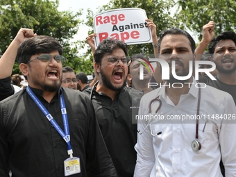 Medical professionals are shouting slogans and holding placards to protest against the rape and murder of a trainee medic at a government-ru...