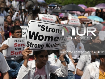 Medical professionals are shouting slogans and holding placards to protest against the rape and murder of a trainee medic at a government-ru...